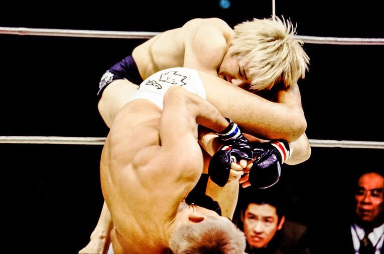 下から関節技を狙う佐藤