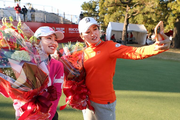 最終戦まで賞金女王の座を争った古江彩佳（左）と記念撮影をする稲見萌寧　©︎Atsushi Tomura/Getty Images