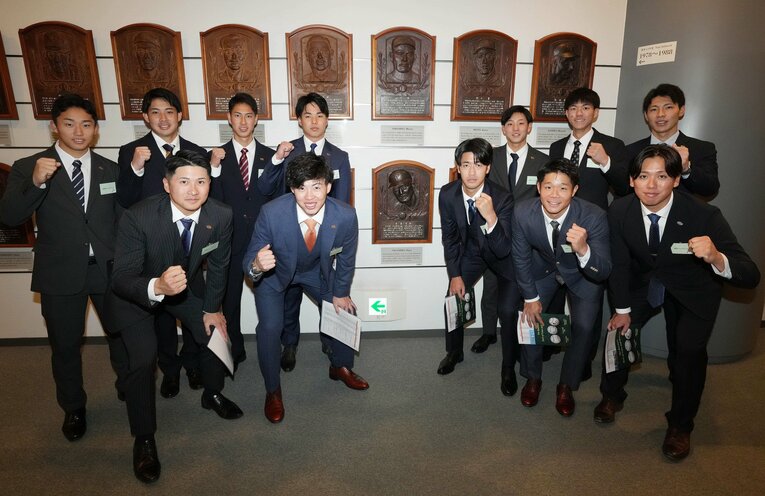 野球殿堂博物館を見学し、長嶋茂雄氏のレリーフを囲み記念撮影するドラフト1位の西舘勇陽（前列右から3人目）ら巨人の新人選手たち　©︎JIJI PRESS 
