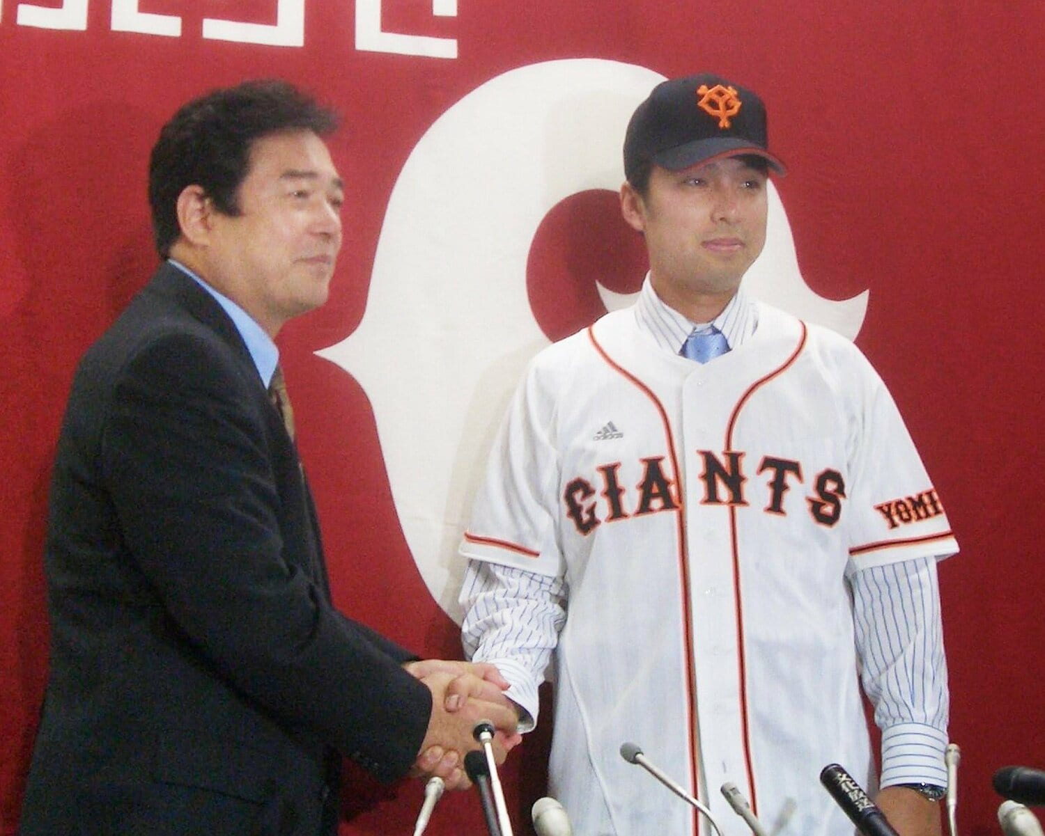 2006年4月、巨人への入団が決まり当時の清武球団代表と握手する小関　©JIJI PRESS