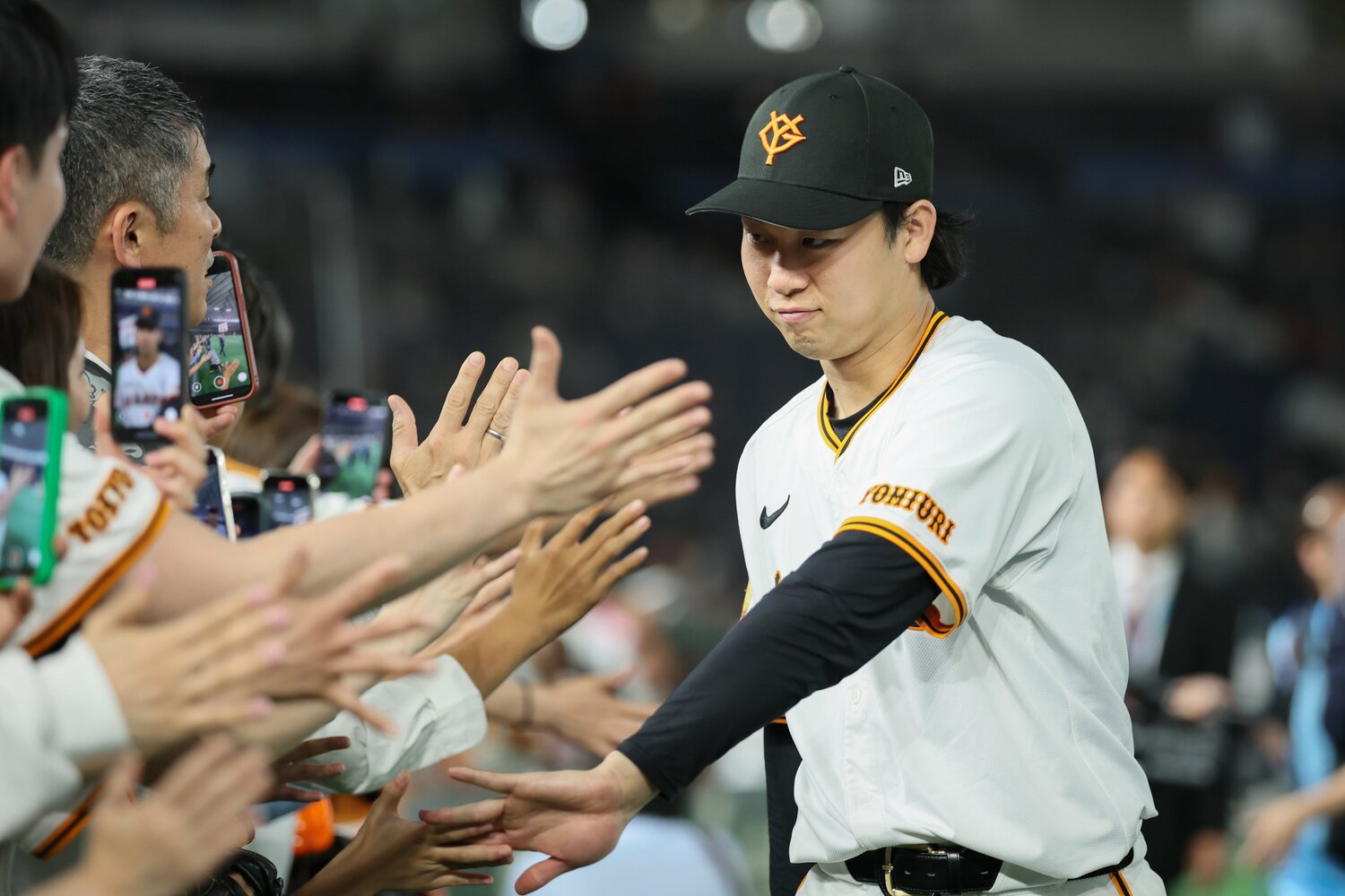 30日の広島戦で無失点に抑え、ファンとハイタッチする山﨑　©JIJI PRESS