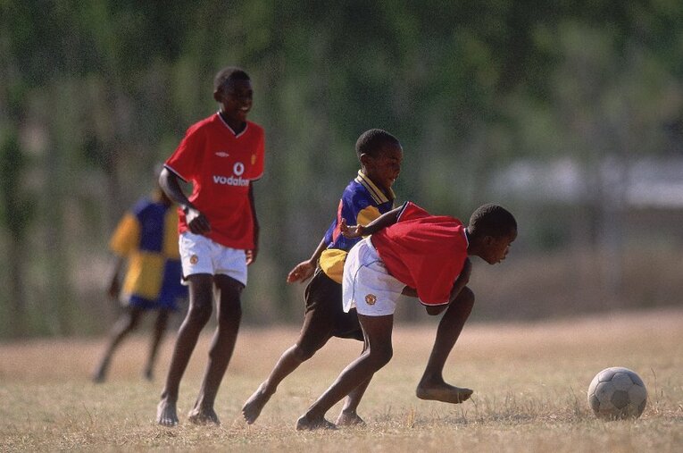 サッカーで遊ぶジンバブエの子どもたち。サッカーが大人気の中で野球を選び取った子どもたちのため、青年時代の堤尚彦はある行動をとる ／ photograph by Getty Images