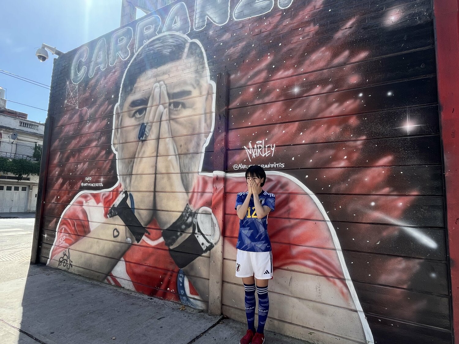 アルゼンチンを訪れた際の眞嶋さん。マラドーナ壁画の前で　※本人提供