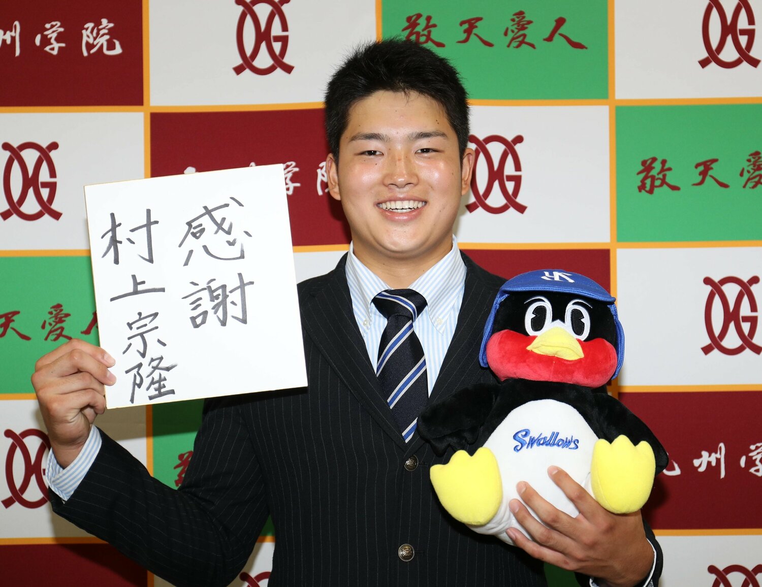 2017年のドラフト会議、ヤクルトから1位指名された村上宗隆（九州学院）。色紙とつば九郎人形を手に笑顔を見せる  ©Sankei Shimbun