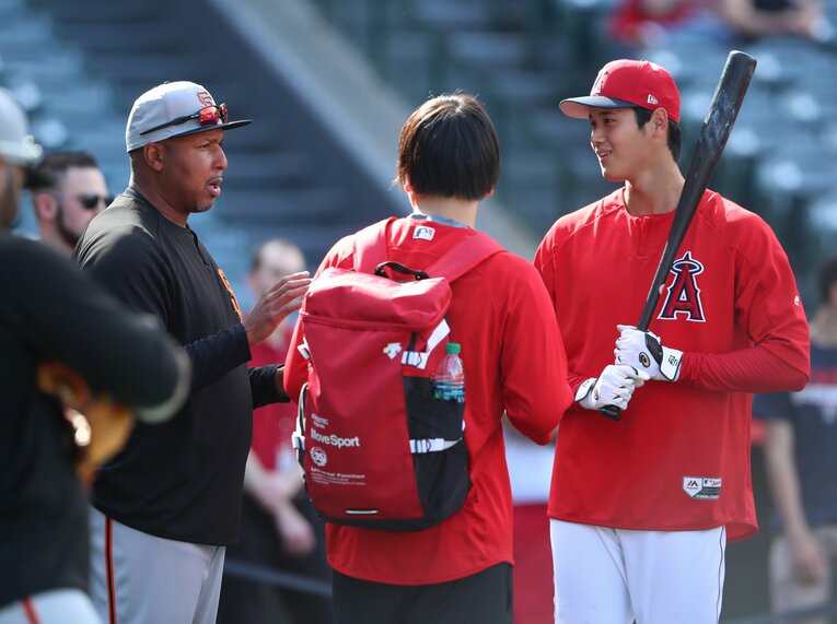 2018年。元中日で現ジャイアンツ打撃コーチのアロンゾ・パウエル氏（左）と話すエンゼルスの大谷翔平（右）　©︎JIJI PRESS
