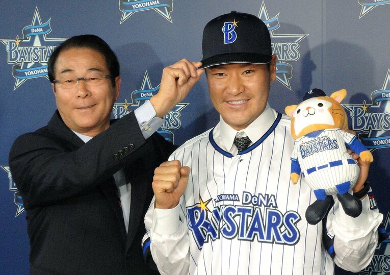 高橋尚成（右）のDeNA入団発表でも帽子をかぶせる高田繁GM　©JIJI PRESS