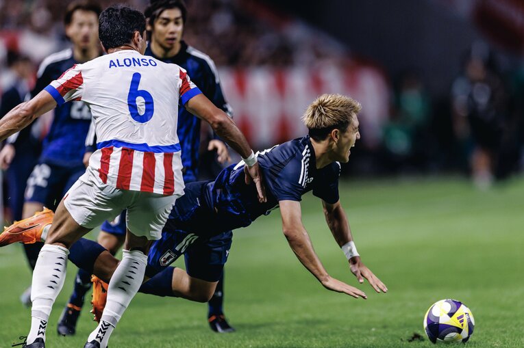 堂安律へのパラグアイの激しいディフェンス（1枚目／全4枚） ©Kiichi Matsumoto