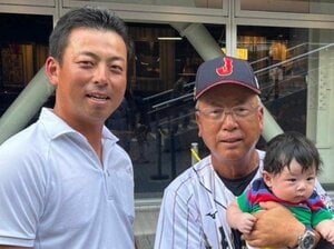 孫の遼正（りょうま）くんを抱き笑顔の明徳義塾高校・馬淵史郎監督（右）。息子で拓殖大の馬淵烈監督（左）は、侍ジャパンU-18 代表を率いた父の応援にも駆け付けた