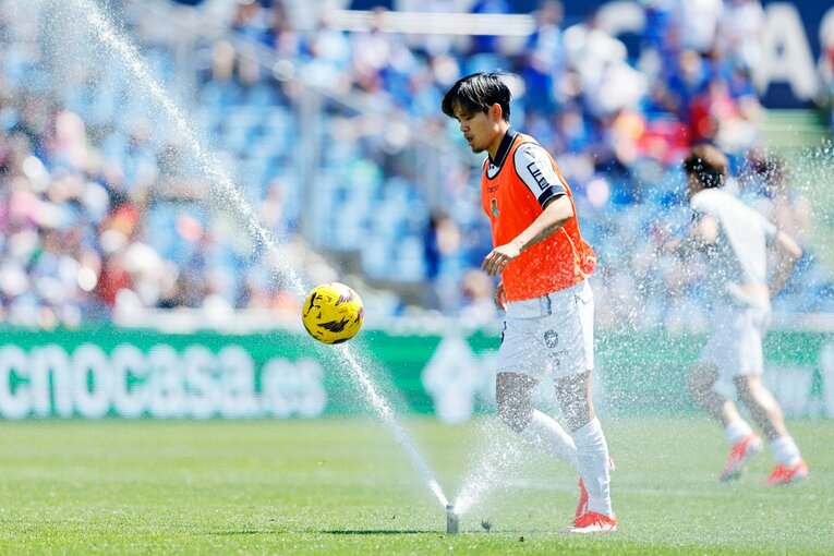 ハーフタイム、スプリンクラーをかわすかのようにボールコントロール