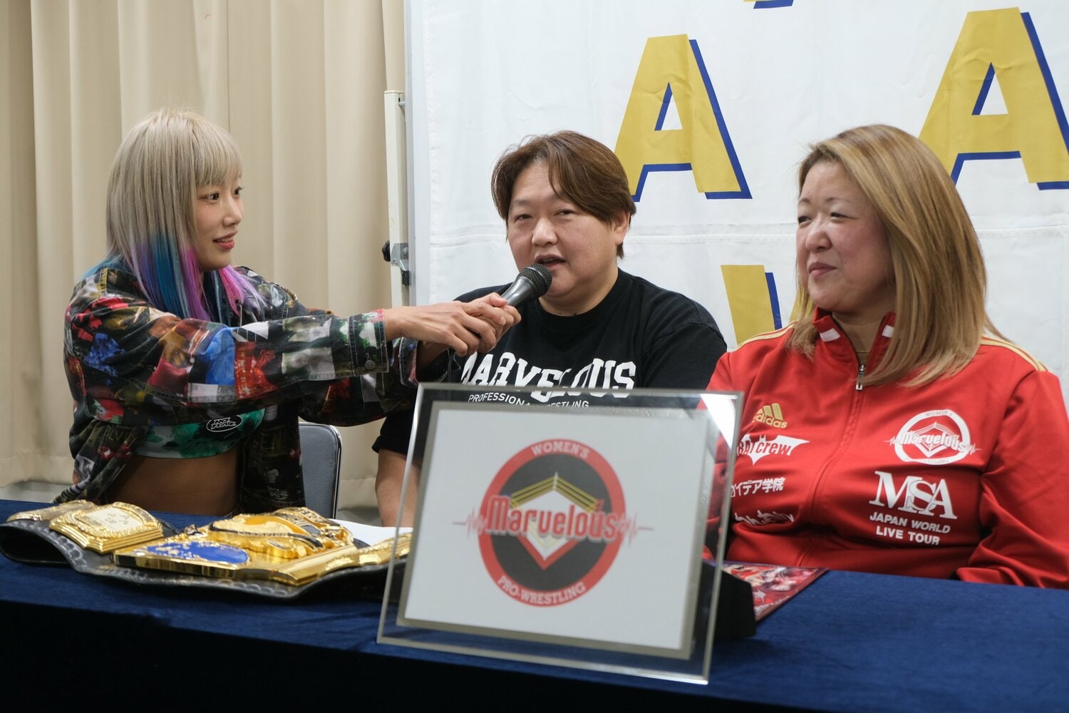 マーベラスの記者会見にて、長与千種にマイクを向けるウナギ