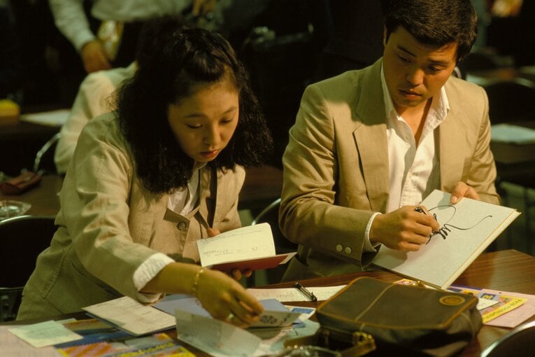 1985年V旅行の手続きをする岡田彰布　©︎Makoto Kenmizaki