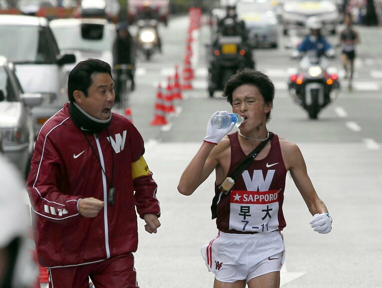 2011年の箱根駅伝、アンカーの中島賢士を激励する渡辺康幸監督。背後には東洋大が迫っていた　©JIJI PRESS