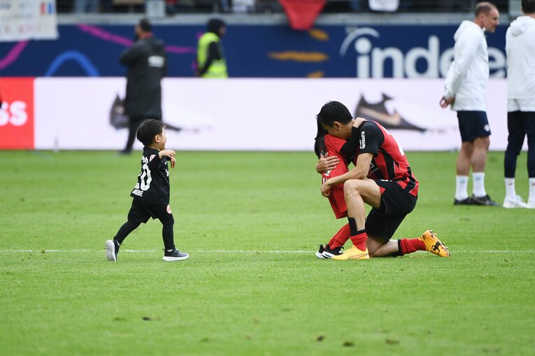 現役最後の試合終了後、娘と息子がピッチ上の長谷部のもとへ。長谷部は子どもとハグし…（スクロールすると他の写真がご覧になれます）　©Itaru Chiba
