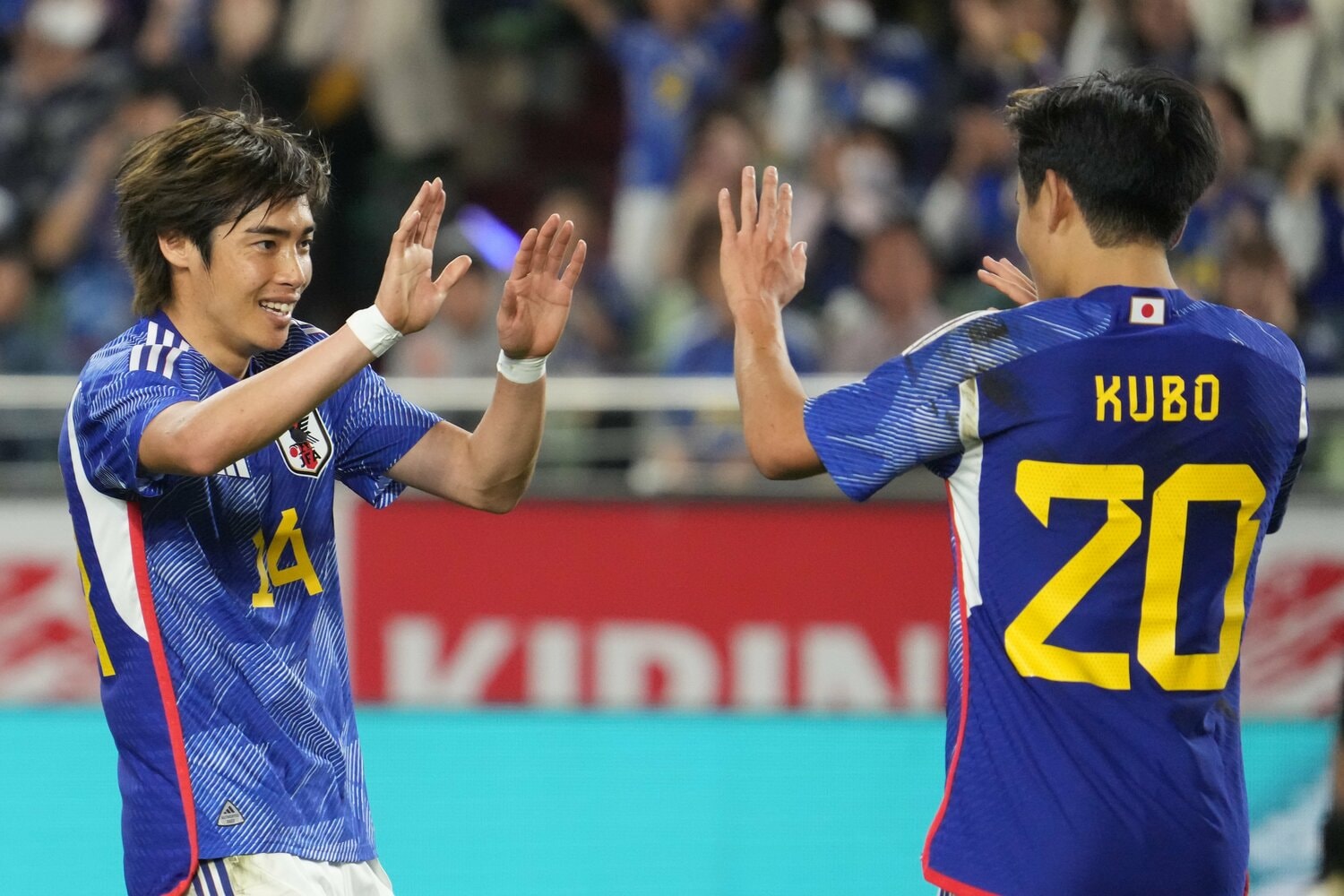 久保建英とハイタッチする伊東純也　©Etsuo Hara/Getty Images