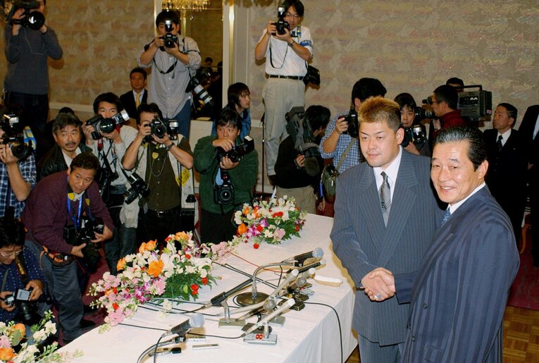 2002年12月21日、近鉄残留を決め、梨田昌孝監督（右端）と握手する中村紀洋 ©JIJI PRESS