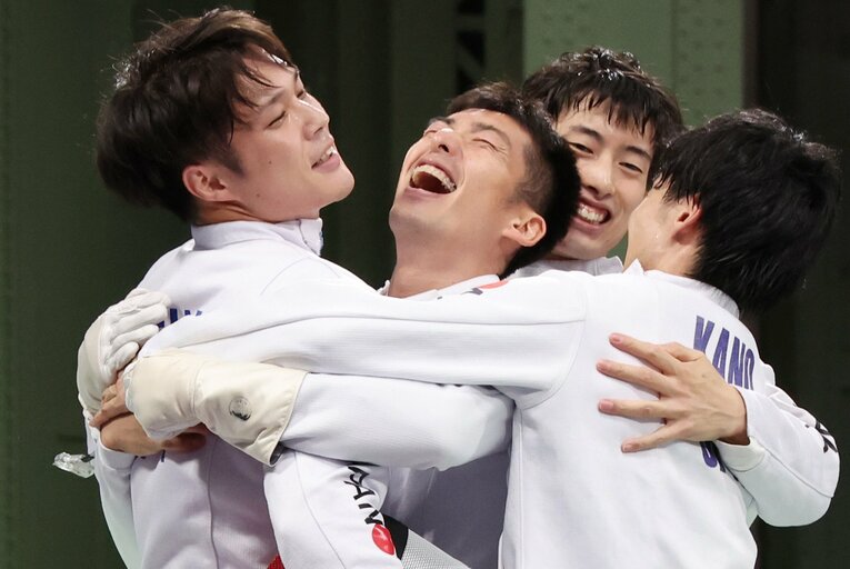 見延和靖を中心に喜び合う男子エペ団体チーム　©JIJI PRESS