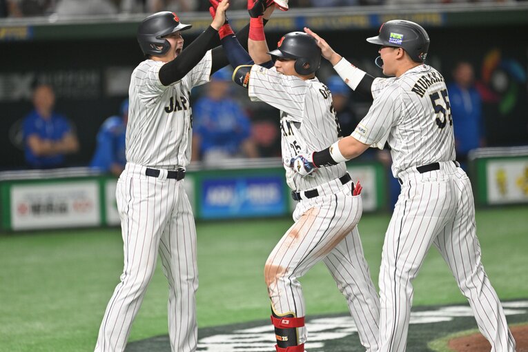 本塁打を放ち、大谷（左）、村上（右）から祝福をうける岡本　©︎Naoya Sanuki