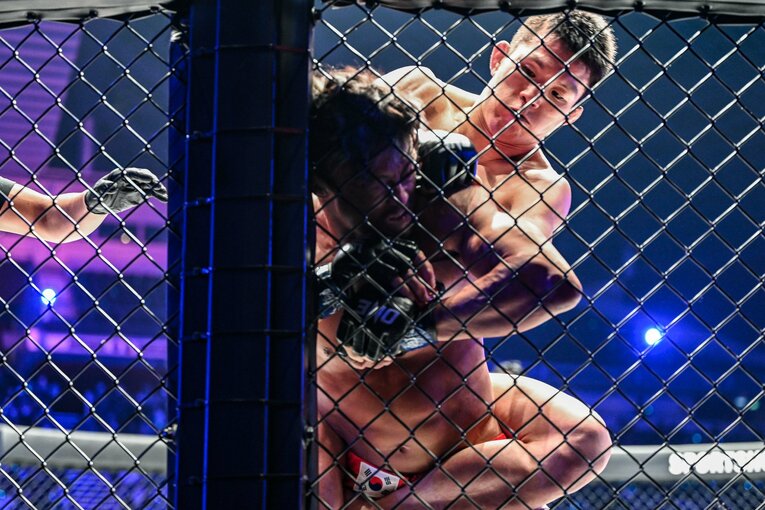 1ラウンド、青木はバックを奪い秋山を攻め込む。裸絞めで落ちかけたと秋山　©ONE Championship