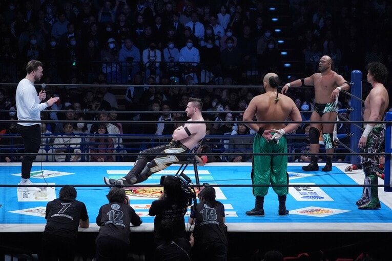 リングの中央でイスに座って足を投げ出しウィル・オスプレイの話を聞くカラム・ニューマン。1月5日、大田区総合体育館　©Essei Hara