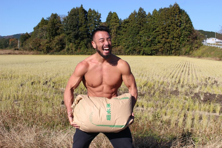 自慢の米を担いでポーズ決める手塚裕之（3枚目／全4枚）©Number Web