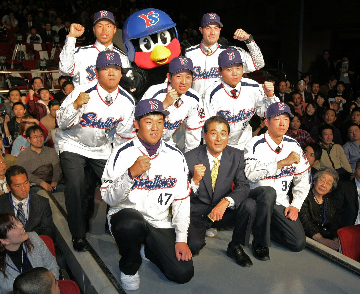 2019年のヤクルト新入団選手。前列左から赤川克紀、高田繁監督、八木亮祐。中列左から新田玄気、日高亮、中村悠平。後列左から塚本浩二、つば九郎、フェルナンデス ©JIJI PRESS