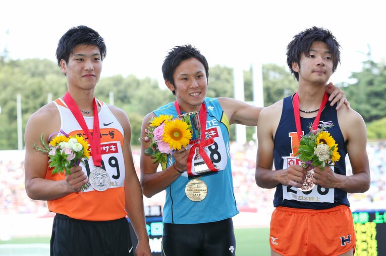 矢澤航（中央）と一緒に表彰台に立つ金井（一番右）　©AFLO