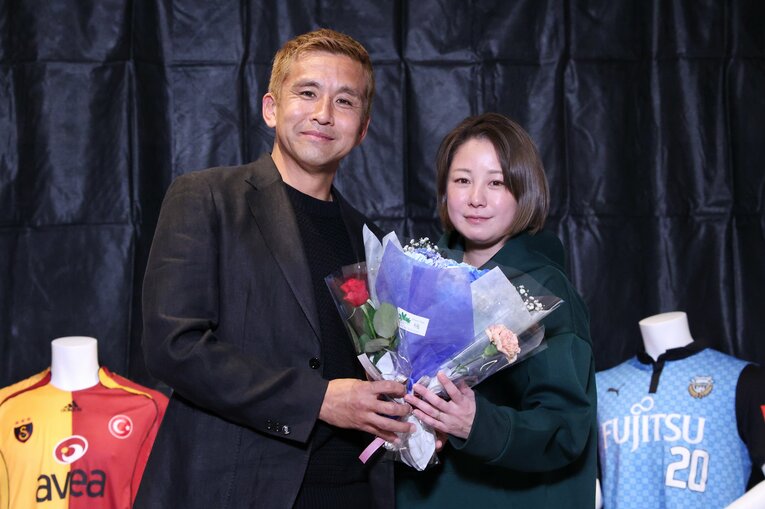 引退会見では夫人から花束を受け取って清々しい表情を見せた　©JIJI PRESS