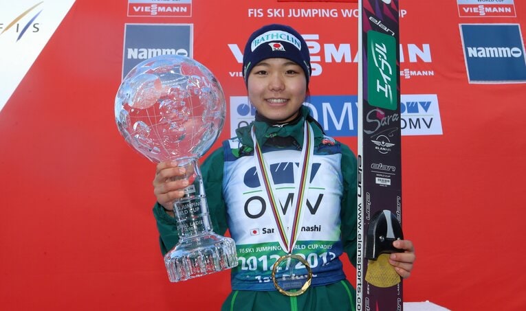 2013年、ワールドカップ総合優勝のトロフィーを掲げる高梨沙羅。男女を通じて日本人初の快挙となった　©AFLO