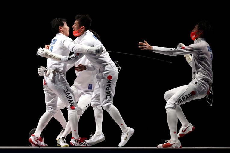 アンカーを務めた加納虹輝に抱きつく見延和靖ら男子エペ団体チーム　©︎Getty Images