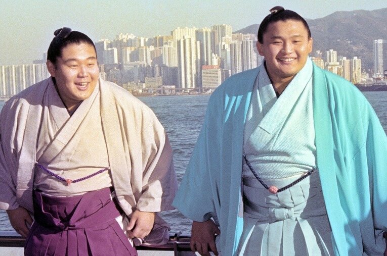 香港島のビル群をバックに笑顔の貴ノ花（右）と若花田（大相撲香港場所で、1993年撮影） ／ photograph by KYODO