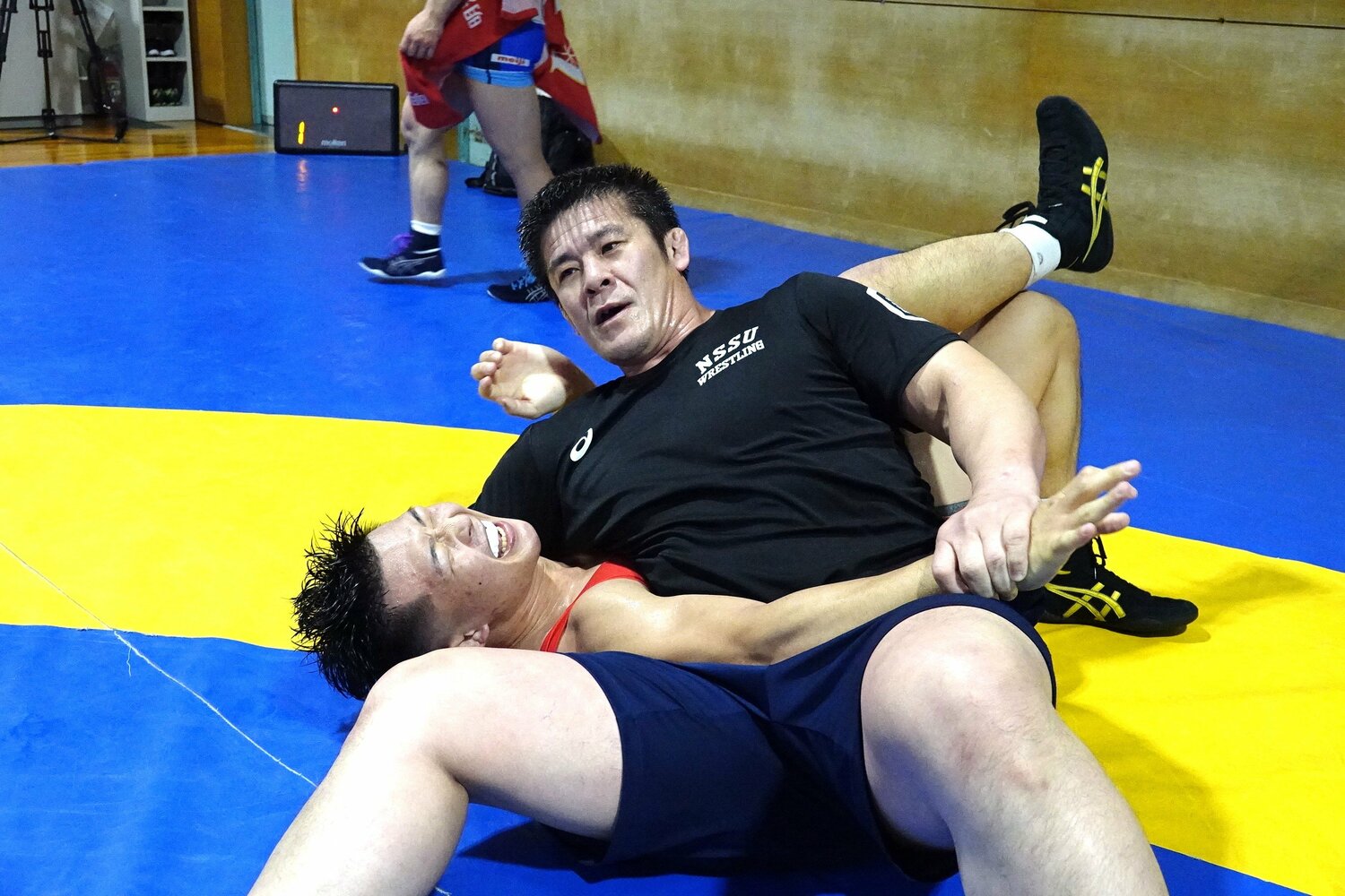 日体大の練習で松本慎吾監督(46歳)に固められる日下尚 ©Koji Fuse