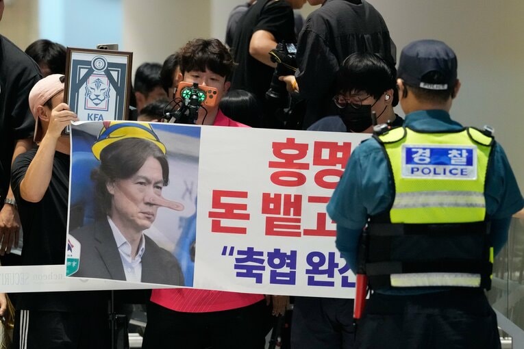 仁川国際空港にて、プラカードを手に抗議する韓国のサポーター【スワイプするとそのほかの写真もご覧になれます】　©AFLO