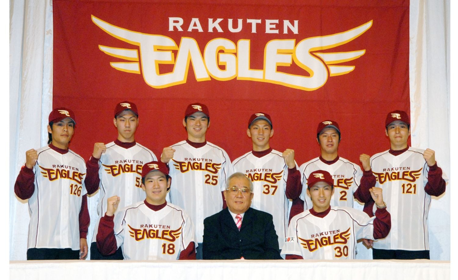 2006年12月、楽天の入団発表でガッツポーズする（後列左から）中村真人外野手、山本大明捕手、横川史学外野手、嶋基宏捕手、渡辺直人内野手、金森久朋投手、（前列左から）田中将大投手、野村克也監督、永井怜投手