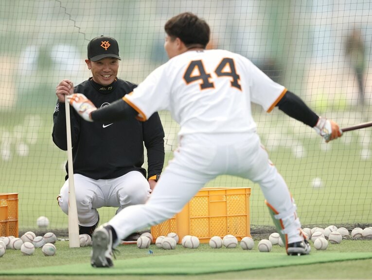 ドラフト3位ルーキー佐々木俊輔（手前）に打撃を指導する阿部慎之助監督　©︎JIJI PRESS