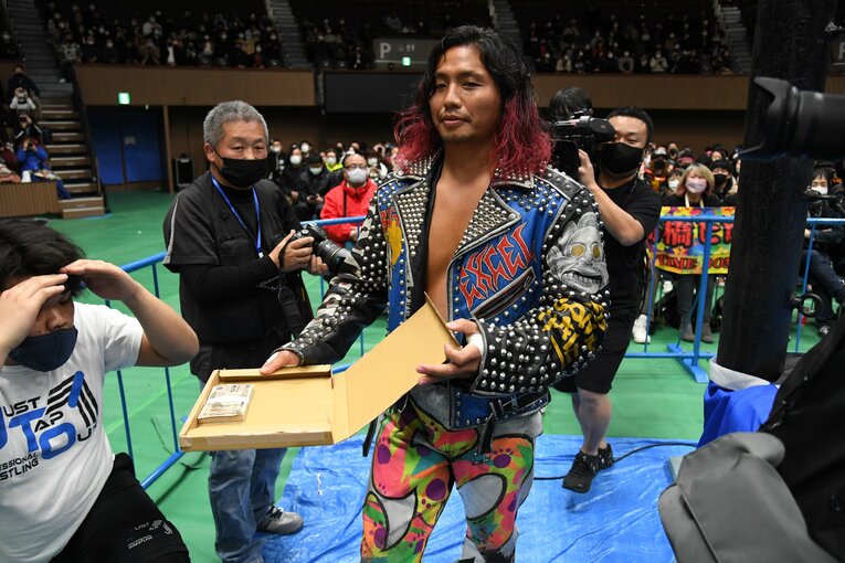 「名も無きヒロムロールまたはみちのくドライバーⅡを返したら100万円懸賞金マッチ」。100万円の札束を持ち込む高橋ヒロム