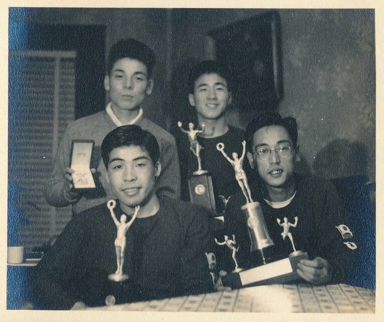 ボストンマラソンの優勝メダルを見せる田中茂樹（後列左・本人提供）