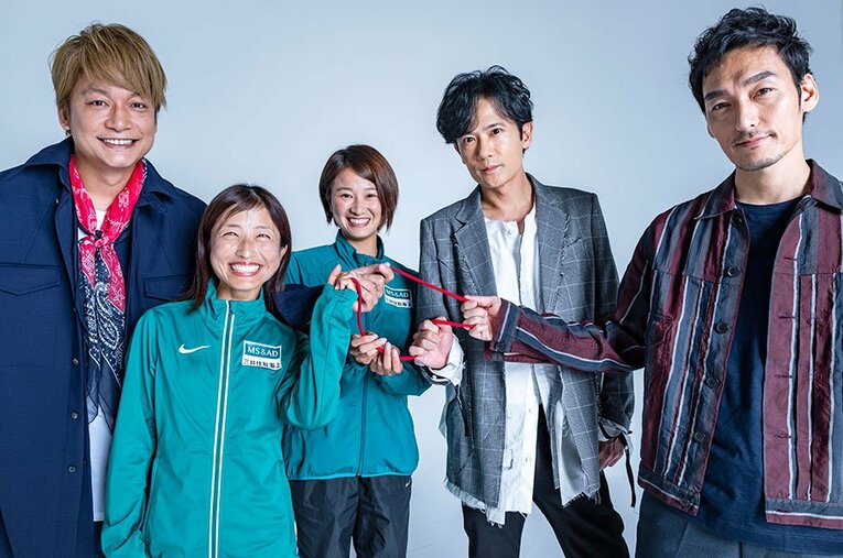 ブラインドランナーの道下美里さん（左）、伴走者の河口恵さんが使うロープを握る3人。 ／ photograph by Takuya Sugiyama