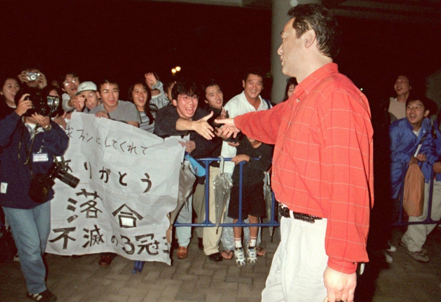 1998年10月7日、日本ハム落合(当時45歳)の現役ラストゲームのあと、球場出口で出待ちしていたファンと握手を交わす ©Sankei Shimbun