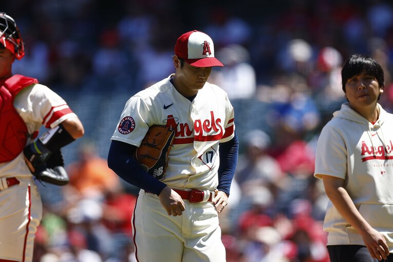 水原通訳とともに、沈んだ表情でマウンドを降りる大谷　©Getty Images