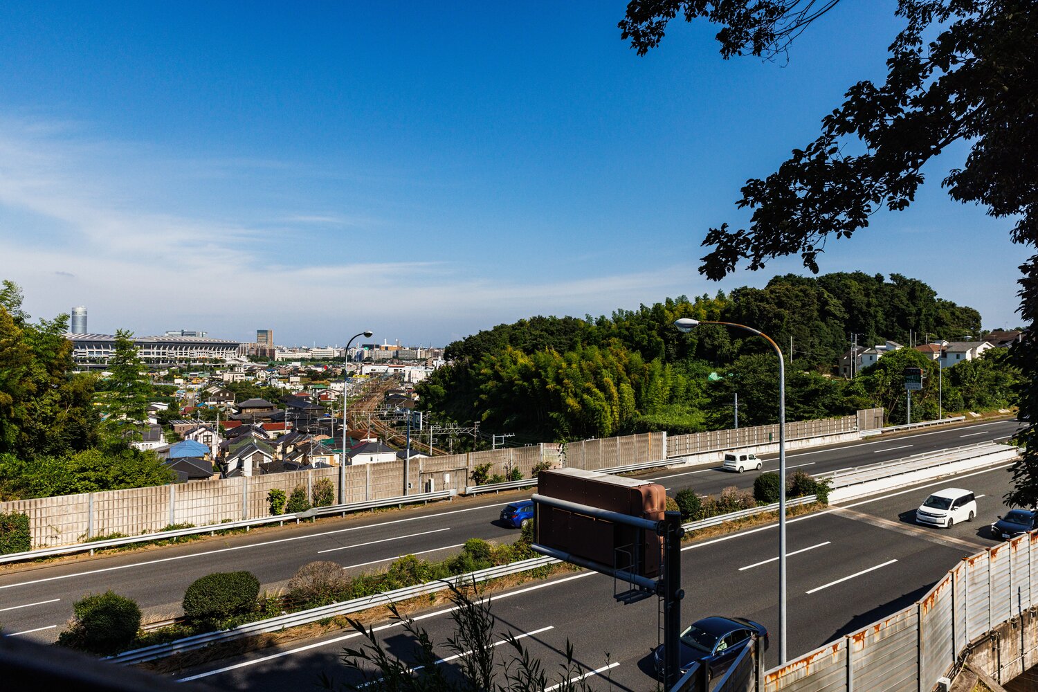 奥に日産スタジアム。手前を走るのが第三京浜（その下を走るのがJR横浜線）。この画面右の森に戦国時代まで小机城があった