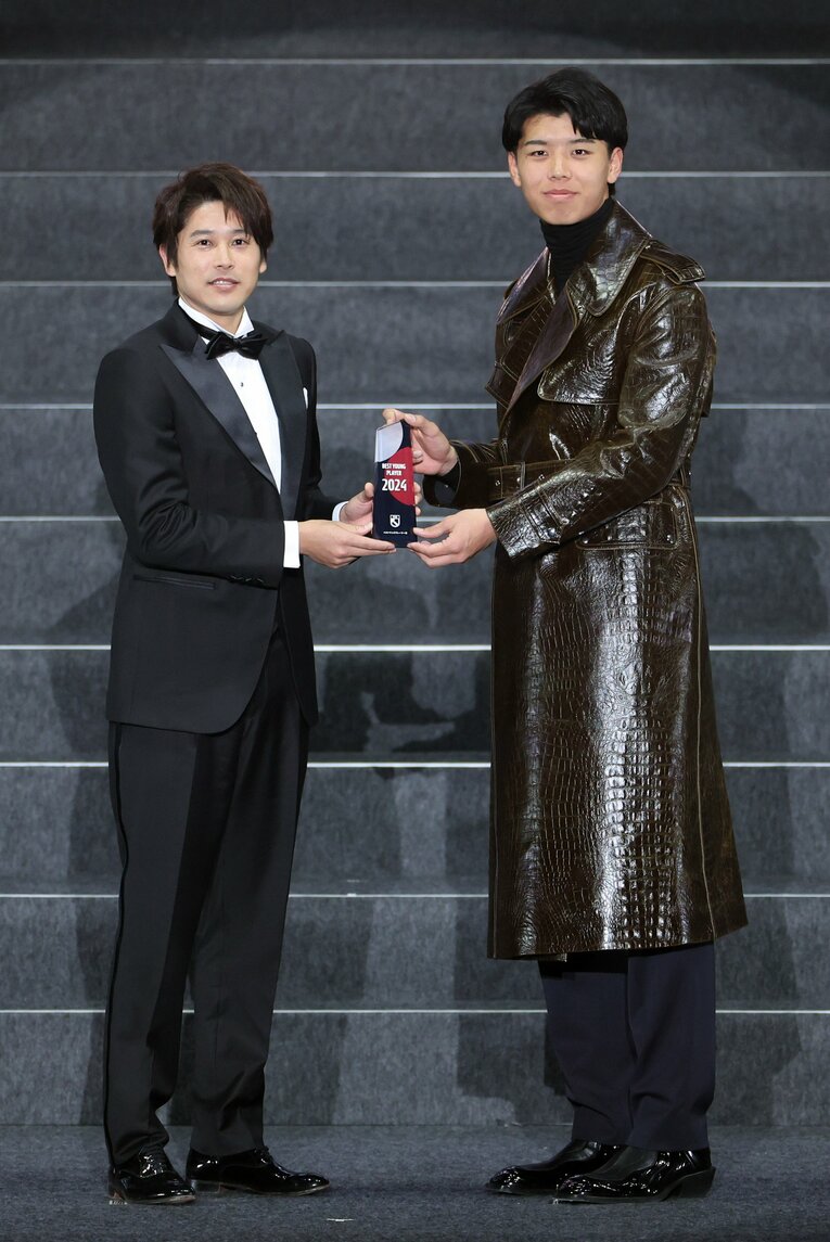 2024Jリーグアウォーズで「ベストヤングプレーヤー賞」を受賞し、内田篤人（左）からトロフィーを受け取る川崎の高井幸大　©︎JIJI PRESS