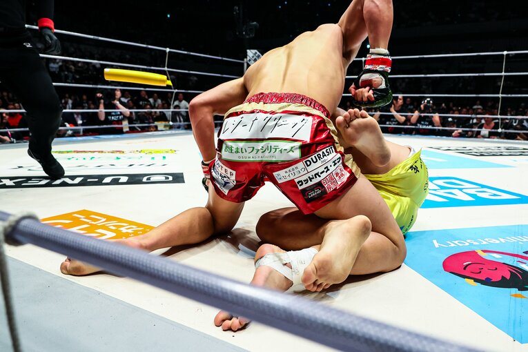追撃のパウンドを緩めなかった鈴木。ストップ用のバトンが投げ込まれた瞬間　©RIZIN FF Susumu Nagao