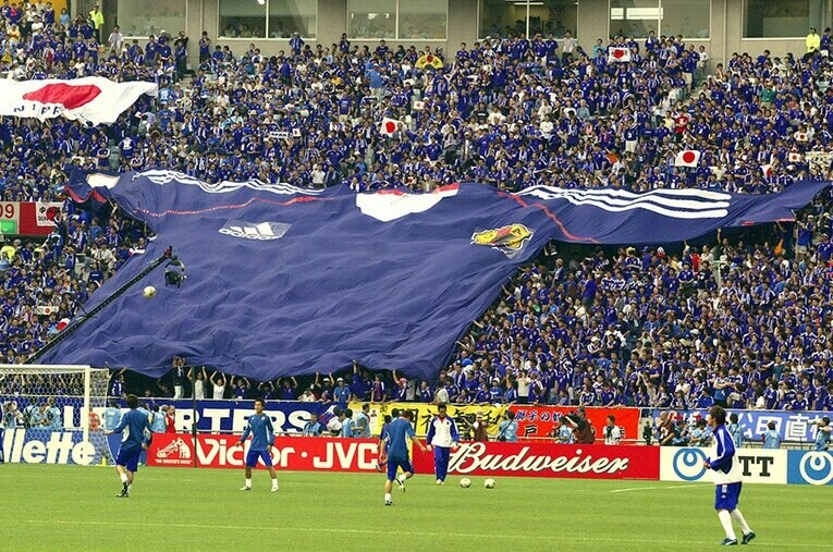 写真は2002年W杯ベルギー戦。そもそも、なぜこんな巨大なユニフォーム（幅28m、100kg）を作ったのだろうか ／ photograph by AFLO