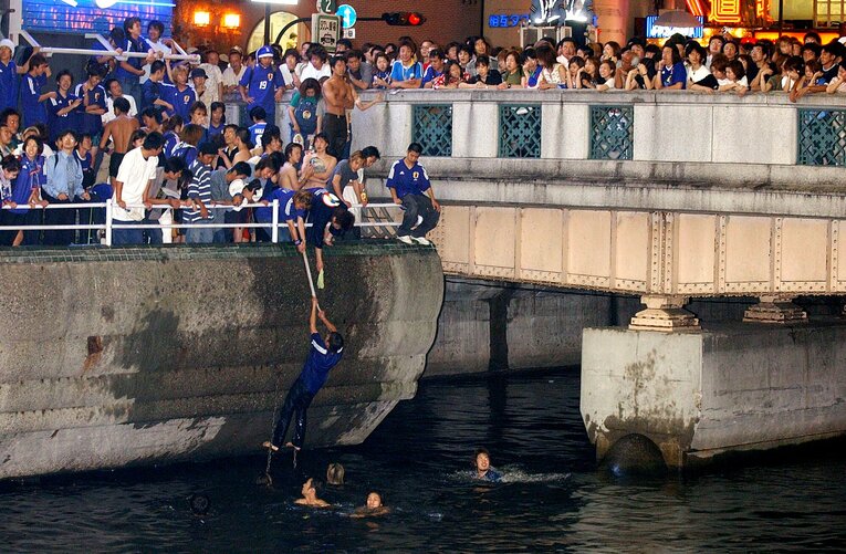 2002年6月、日韓W杯で日本代表の決勝トーナメント進出が決まり、道頓堀川に飛び込む若者　©JIJI PRESS