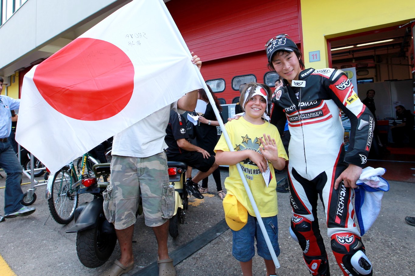 イタリアGPで富沢を応援する地元の少年がピットを訪れ、記念撮影。しょーやは子どもたちからも好かれる選手だった　©Satoshi Endo
