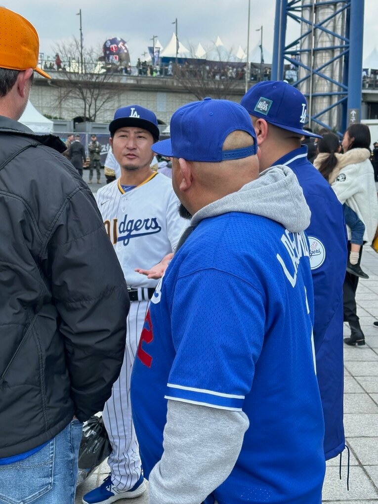 【開幕第1戦／20日】ドジャースファンに取り囲まれている（？）ミニ谷氏