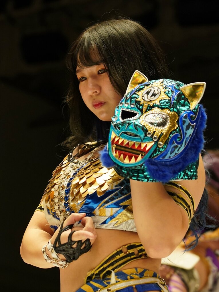 リング上でマスクを手にポーズを決める