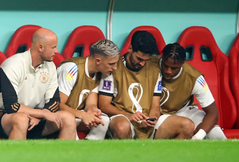 試合途中にスマホを取り出し、日本対スペインの試合結果を確認するギュンドアンらドイツ選手たち　©Getty Images