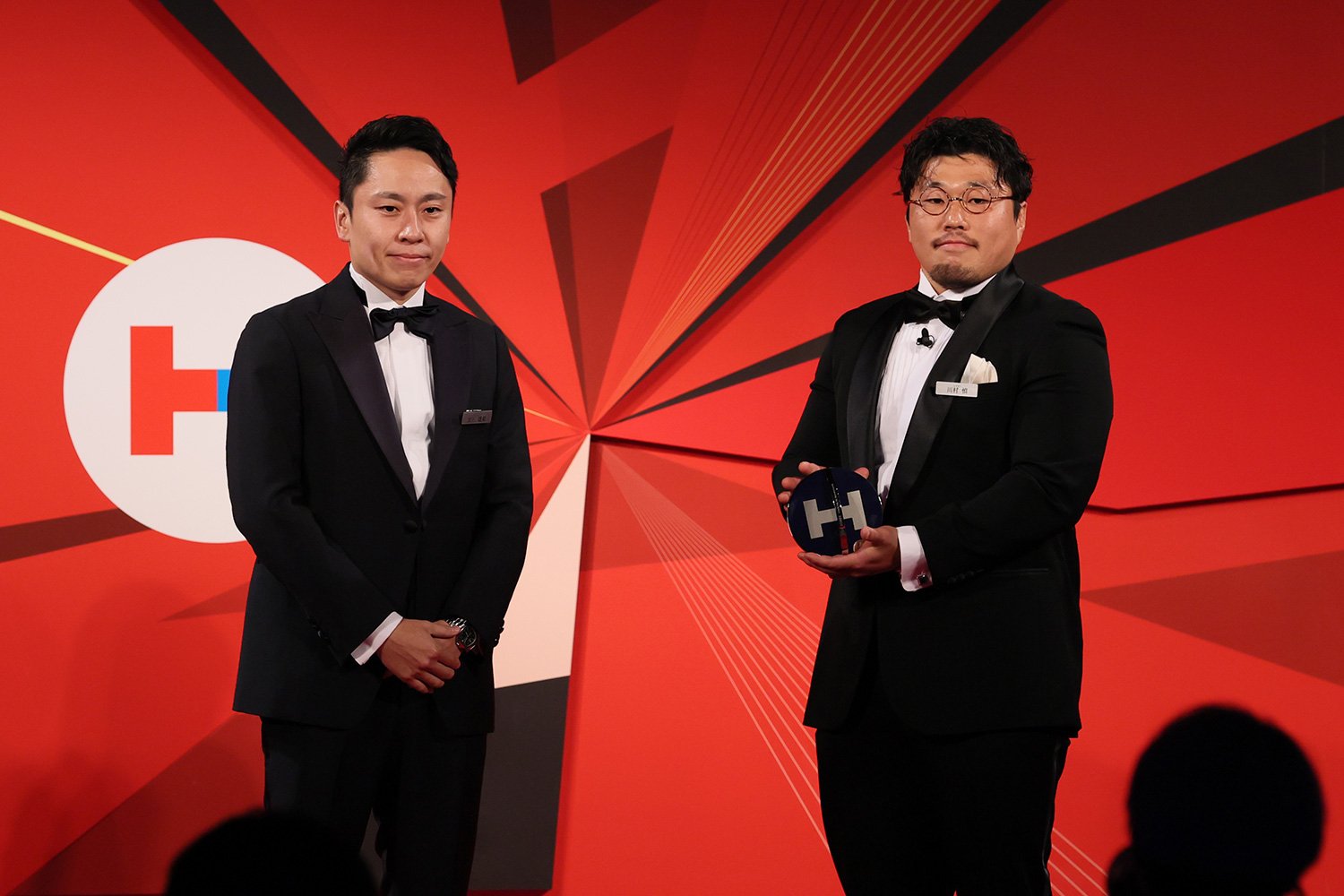 プレゼンターの太田雄貴さん（左）から、トロフィーを受け取る川村慎さん