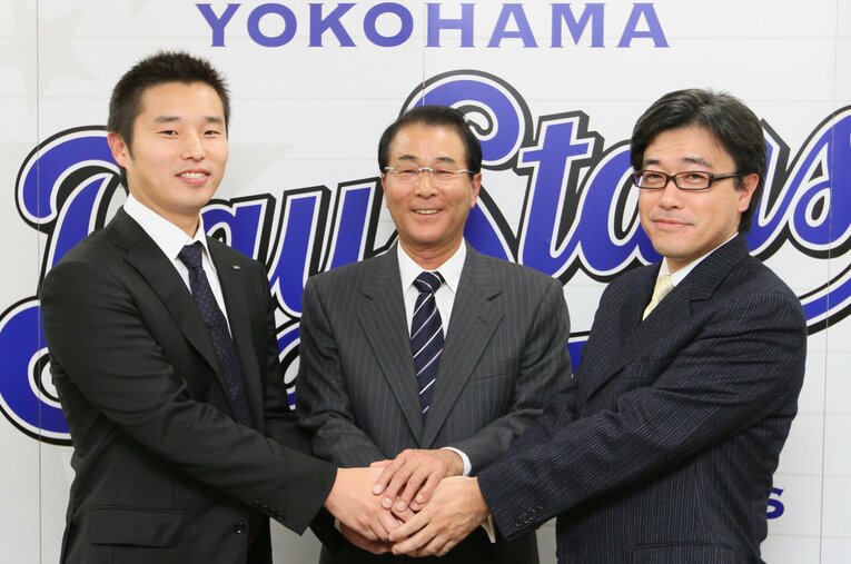GM就任記者会見で、春田真オーナー（右）、池田純球団社長（左）と握手する高田繁　©JIJI PRESS